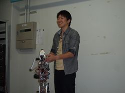 大学院修士課程の学生がロボットアームを操作する様子